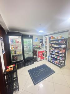 Una tienda de comestibles con dos refrigeradores y una alfombra azul. en SUITE PREMIO CABO BRANCo, en João Pessoa
