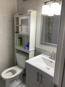Un baño blanco con inodoro y lavabo. en Comfy Private Room, en Brampton