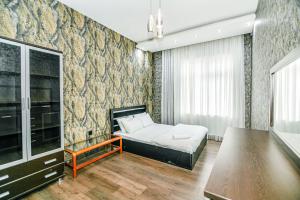 een slaapkamer met een bed en een tafel erin bij SEA ViEW HOTELAPARTMENT MCDONALD'S in Baku