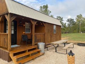 a wooden cabin with a bench and a table at Cozy little Cabin in Van Buren
