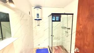 a shower with a glass door in a bathroom at Casitas Atlántida in Atlántida +106 photos
