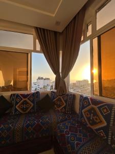- une chambre avec un canapé et une grande fenêtre dans l'établissement Ami D'or Hostel, à Taghazout
