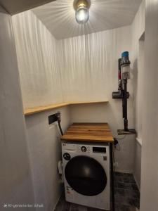 una pequeña cocina con lavadora y secadora en una habitación en Altstadt Blick an der Donau, en Passau 3 fotos más