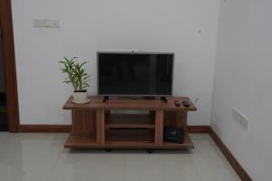 a television on a wooden stand in a room at Modern 3 BR Apt in Dehiwala