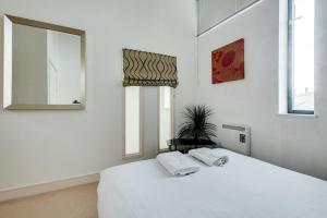a white bedroom with a bed and two windows at Elegant Oxford Flat - Central Spacious Comfortable in Oxford