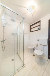 a bathroom with a glass shower and a toilet at João Loft Ii by Mth in Campanário