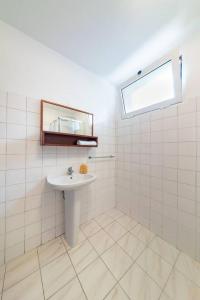 a white tiled bathroom with a sink and a window at João Loft Ii by Mth in Campanário +20 photos