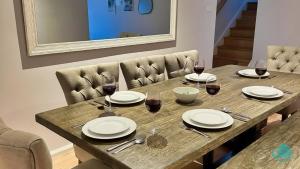 a wooden table with plates and wine glasses on it at Lake Breeze - lakeside, bushland escape, with plunge pool in Cams Wharf