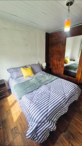 a bedroom with a large bed with a striped comforter at Renacer in Piriápolis