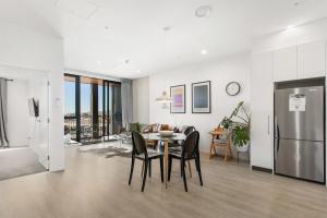 Una cocina y una sala de estar con mesa y sillas. en Live the High Life 1 Bdrm Luxury With Park, en Christchurch 10 fotos más