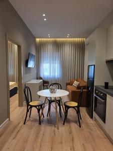 eine Küche und ein Wohnzimmer mit Tisch und Stühlen in der Unterkunft Rroji Urban Heritage in Shkodra