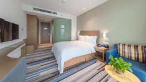 a hotel room with a bed and a blue couch at Holiday Inn Express - Suzhou Industrial Park by IHG in Suzhou +42 photos