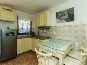una cocina con una mesa y un refrigerador en Two-Bedroom Holiday Home With Pool, en Brodarica