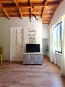 a living room with a television on a dresser at Nido Del Bosque in Pucón +72 photos