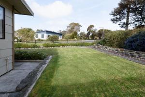 a backyard with a lawn and a house at Lulworth Coastal Getaway - Close To The Beach in Lulworth