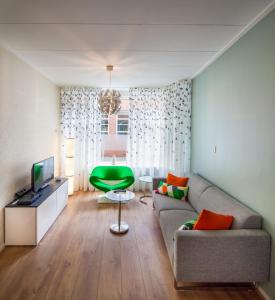 a living room with a couch and a green chair at Stay 19 - 2 bedroom hotelapartment with free parking in Groningen