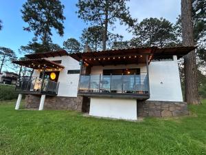 a white house with a stone wall at Cabaña DAGO in Mazamitla