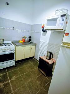 Una cocina con estufa y refrigerador blanco. en Despertar, en Santa Rosa