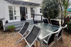 Una mesa y sillas en un patio. en Location Location 400m From Beach and Town Centre, en Whitianga