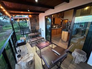 a screened in porch with chairs and a kitchen at Cabaña DAGO in Mazamitla
