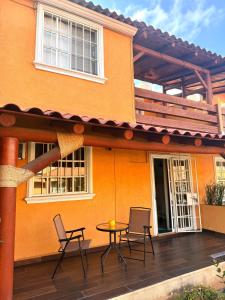 a patio with chairs and a table in front of a house at Casa Morroken Ixtapa con Alberca in Ixtapa