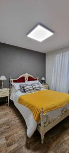 a bedroom with a large bed with a yellow blanket at Beautiful apartment in San Bernardo with terrace in Costa Azul