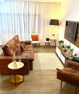 un salon avec un canapé et une télévision dans l'établissement Lourenço House, à Barueri