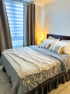 a large bed in a bedroom with a window at Departamento Urban Stay Los Ángeles in Los Ángeles