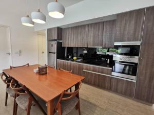 a kitchen with a wooden table with chairs and a dining room at By The Sea - SDBMS in Batu Ferringhi