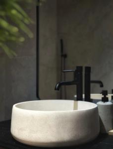 a white sink in a bathroom with two faucets at Private Patio and Parking KING BED Elegant Retreat in Pittsburgh