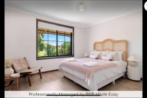 ein Schlafzimmer mit großem Bett und Fenster in der Unterkunft Oleander Cottage in Lake Albert