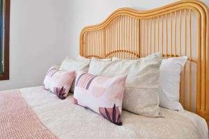 ein Bett mit vier Kissen und einem Kopfteil aus Holz in der Unterkunft Oleander Cottage in Lake Albert + 5 Fotos