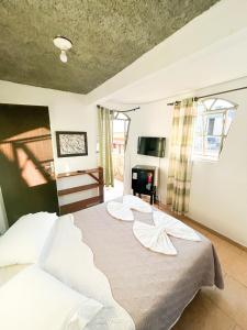 a bedroom with a large bed with white sheets at Pousada King Stones - São Thomé das Letras - ÁREA CENTRAL in São Thomé das Letras +39 photos