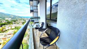 two chairs sitting on the balcony of a building at Apartamento Luxury ubicado en la mejor zona comercial de la ciudad in Ibagué