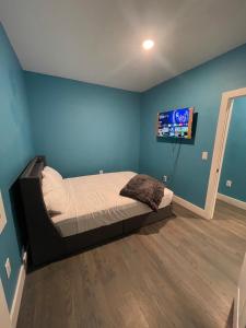 a bedroom with a bed and a tv on the wall at Cozy Short Stay in Newark