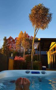 a person in a hot tub with their feet in it at Ski Country Chalet in Ohakune