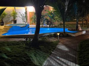a swimming pool in a yard with a palm tree at Sirena's Beach & Surf Club in Canoa