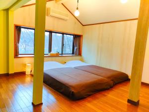 a bedroom with a large bed in a room at 貸別荘 時々チョコレート in Kofu