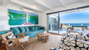 a living room with a blue couch and chairs at '33 Degrees - Stunning Views' by HolidayCo in Hardys Bay