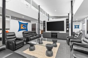 a living room with leather chairs and a flat screen tv at The Prescription Pad - Group Getaway for Families in Port Sorell
