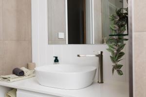 Un baño con un lavabo blanco y un espejo. en Hidden Gem, en Urunga 7 fotos más