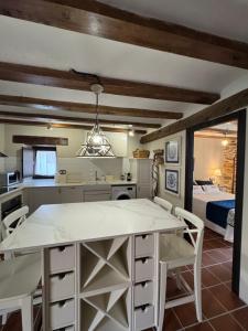 a kitchen with a table and chairs and a bedroom at El Rincón de la Tía Miguela in Puertomingalvo +39 photos
