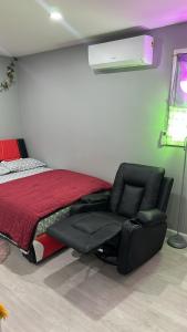1 dormitorio con 1 cama y 1 silla reclinable en Unit #10 Private Studio, en Hempstead