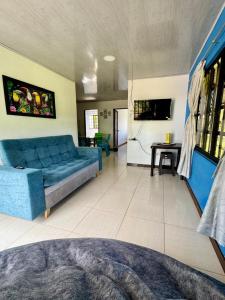 a living room with a blue couch and a table at Jacuzzi - flores en la colina 2 in Bellavista