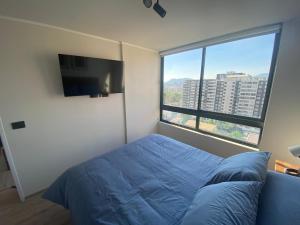 a bedroom with a bed and a flat screen tv at Nuñoa a un paso de todo lo que necesitas in Santiago