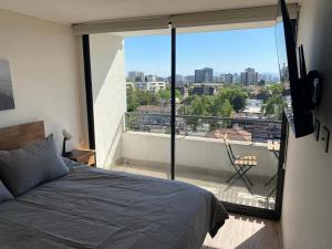 a bedroom with a bed and a balcony with a view at Nuñoa a un paso de todo lo que necesitas in Santiago +39 photos