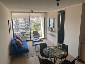 a living room with a blue couch and a table at Nuñoa a un paso de todo lo que necesitas in Santiago