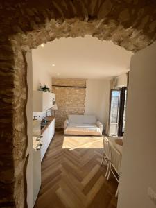 a bedroom with a bed and a stone wall at Cuore Antico - Il Monastero Sul Mare in Vieste