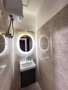 a bathroom with a sink and a mirror at Cozy Lovely 1 bedroom apartment in Tema