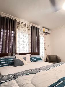 a bedroom with a large bed with blue and white pillows at Cozy Lovely 1 bedroom apartment in Tema